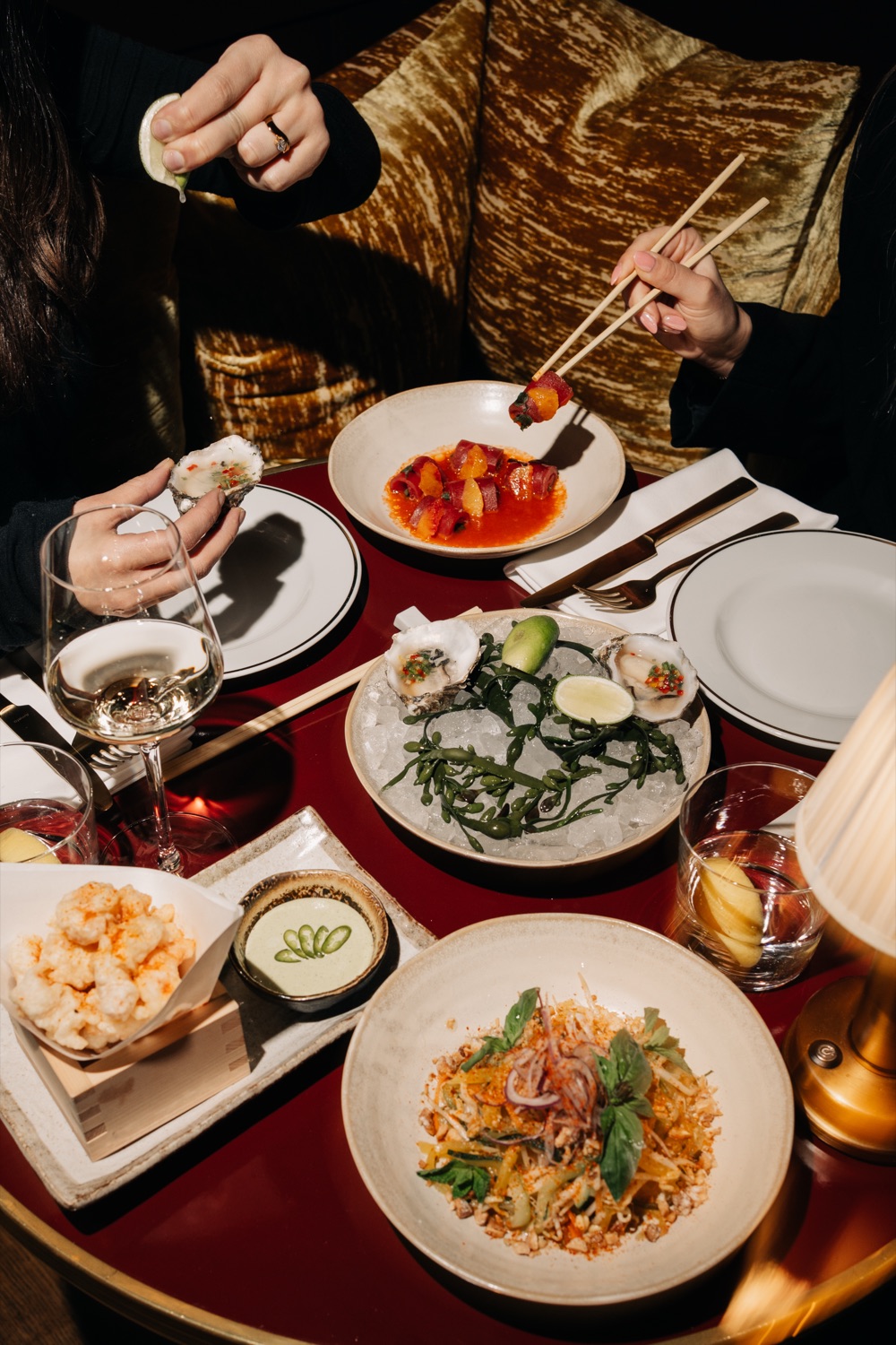 A shared table of sushi, salad and plates to pass around