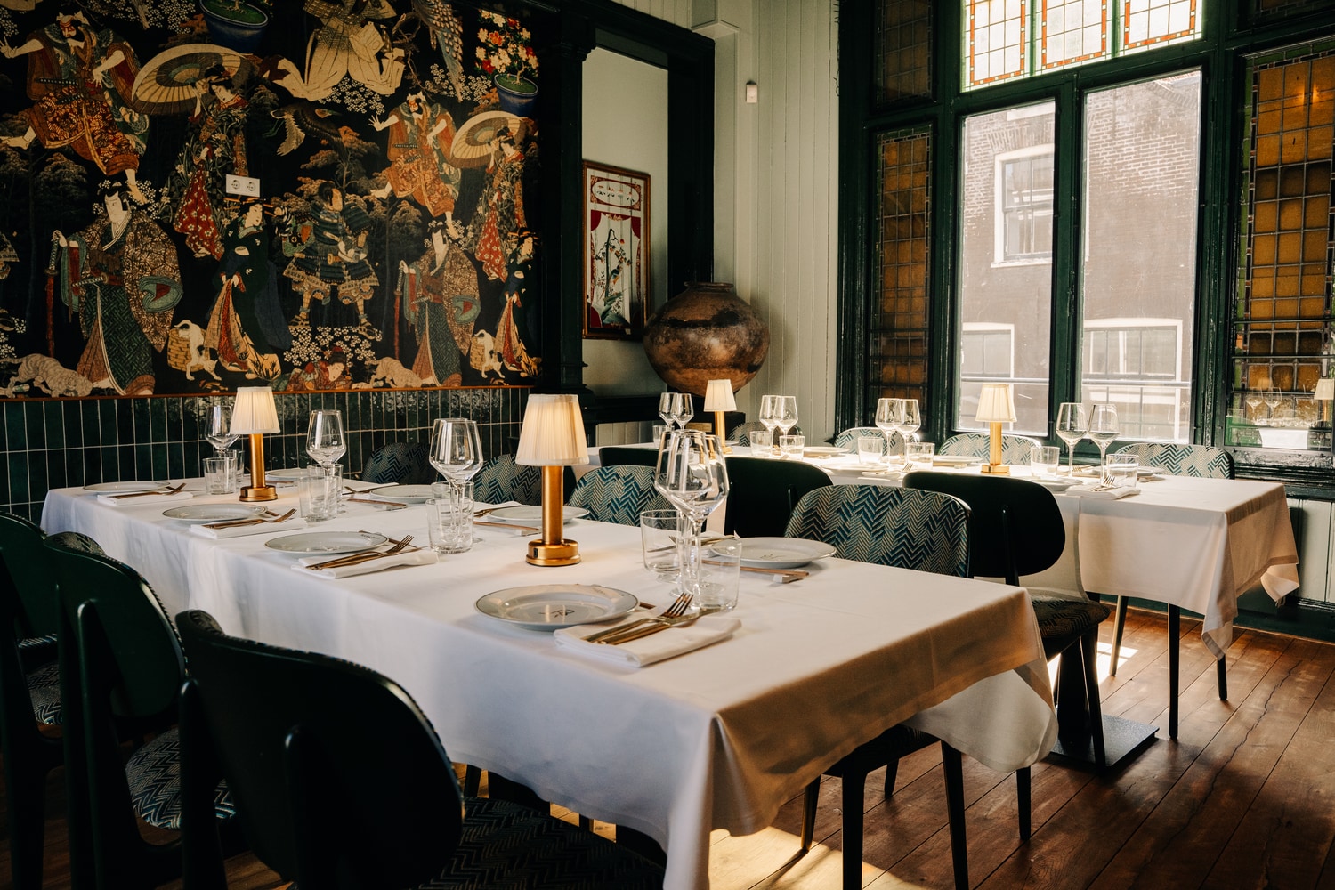 De private dining room, één lange gedekte tafel onder een wandtapijt