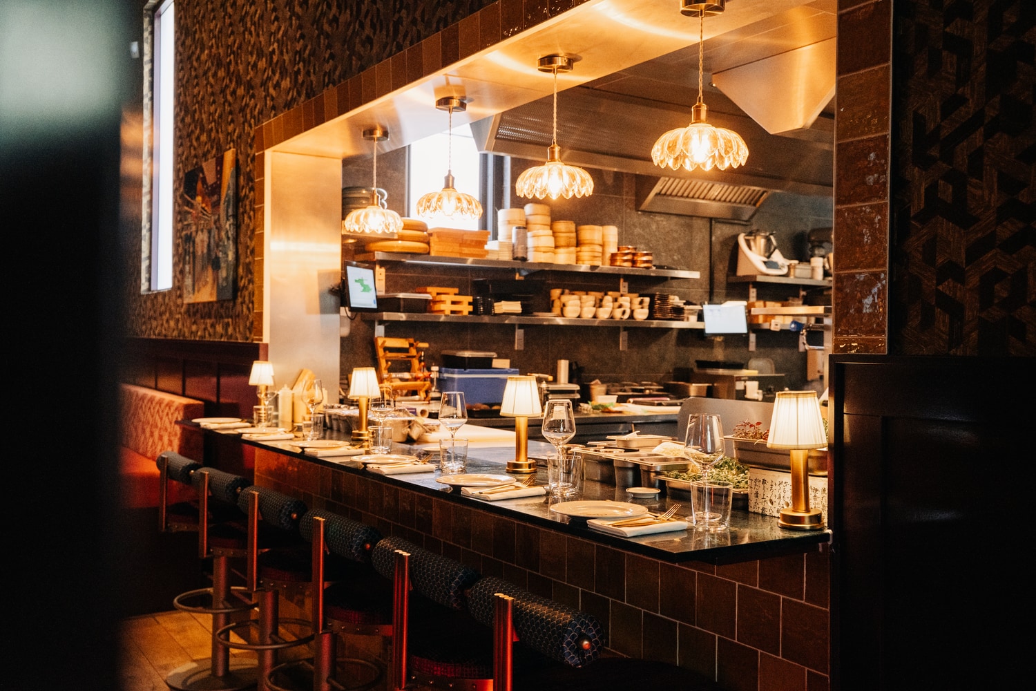 De open keuken gezien over de chef's table-bar in warm licht