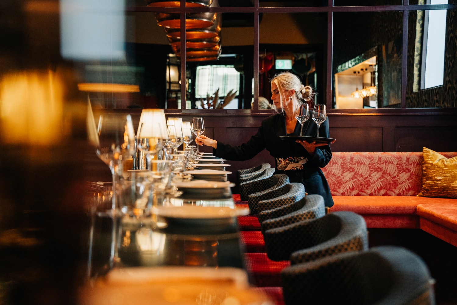 A guest at the bar with glassware lined up along the counter
